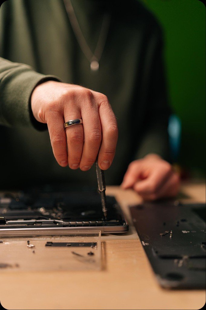 Technician repairing a laptop with precision tools